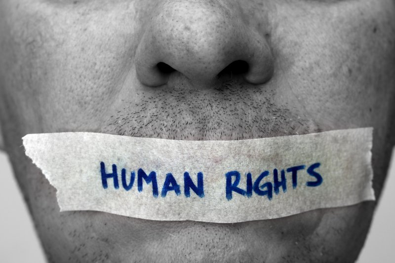 Half face with tape over the mouth with the text HUMAN RIGHTS